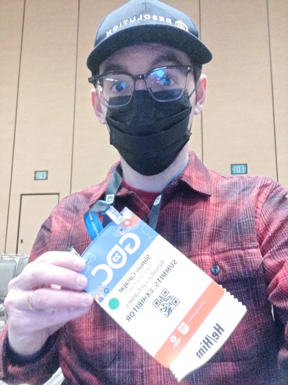 Holding up my GDC badge